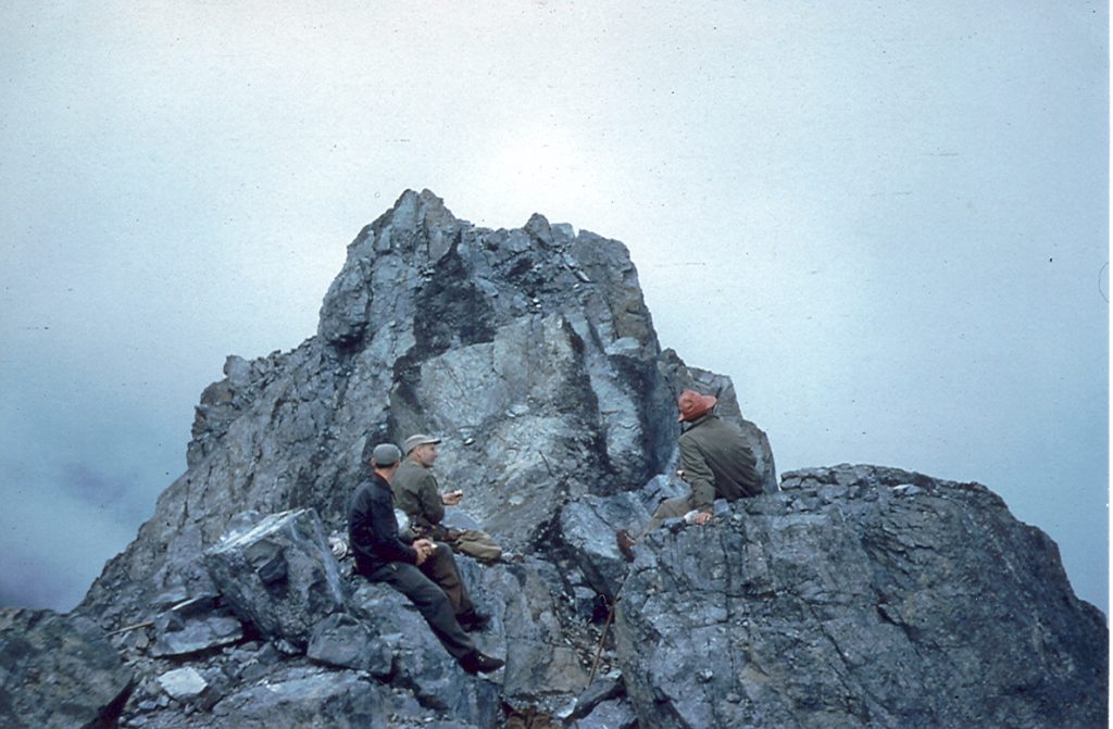 L-R Syd Watts, Bill Lash and Mallory Lash sitting on the Southeast Peak of Mt. Colonel Foster with the Southwest Peak behind1954 – Patrick Guilbride photo.
