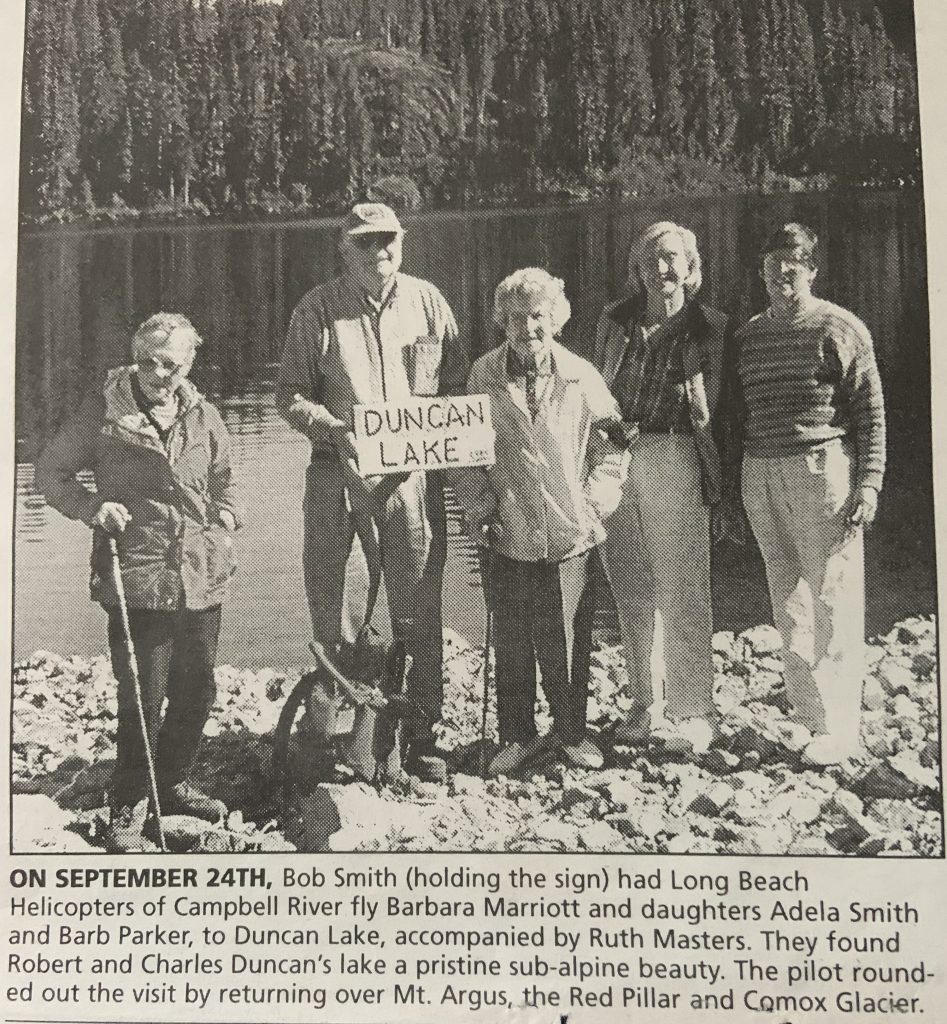 On September 24th, Bob Smith (holding the sign) had Long Beach Helicopters of Campbell River fly Barbara Marriott and daughter Adele Smith and Barb Parker, to Duncan Lake, accompanied by Ruth Masters (left). They found Robert and Charles Duncan’s lake a pristine sub-alpine beauty. The pilot rounded out eh visit by returning over Argus Mountain, the Red Pillar and Comox Glacier.