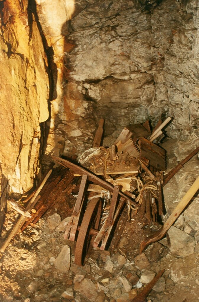 A wheelbarrow containing fuse wire and dynamite sticks in a storage adit on Big Interior Mountain (1993) – Lindsay Elms photo