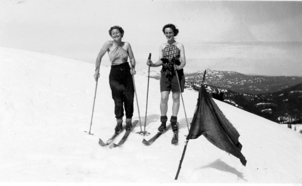 Mia Schjelderup and Katherine Capes skiing on Mt. Becher. Both have bare arms, one is in shorts.