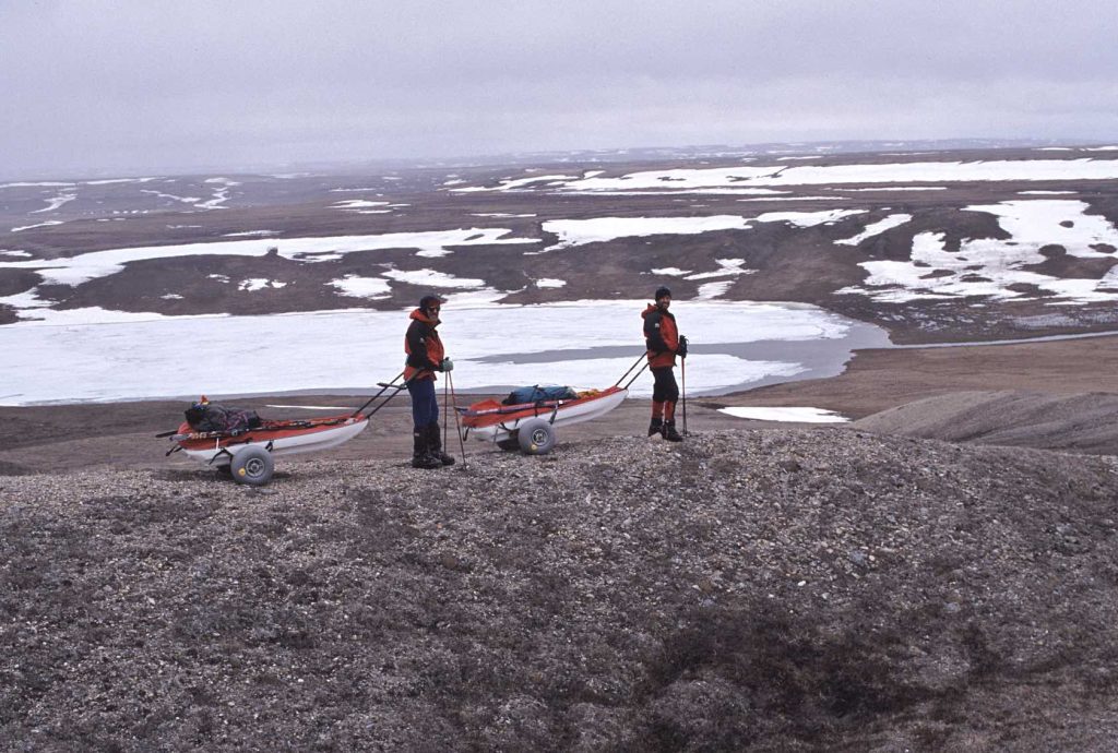 Sandy Briggs and John Dunn using John’s ’secret weapon’, sled wheels, for traversing the tundra when the snow is gone. Tuktut Nogait National Park 2003 – Sandy Briggs photo.